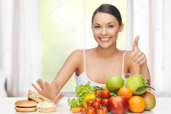 A woman with fruits rejecting hamburger and cake 